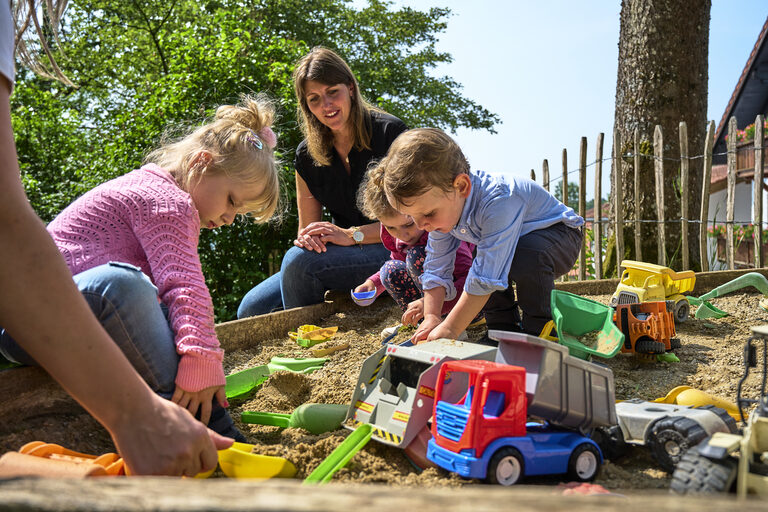 Spielende Kinder im Sandkasten des Kinderparadies Höcker.